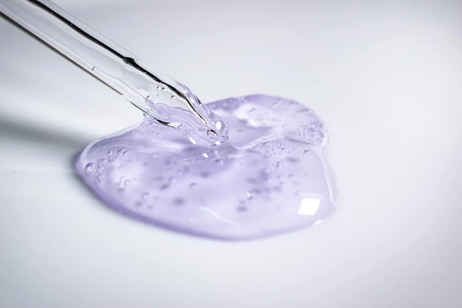A pipette dispensing a clean cosmetic active gel during formulation